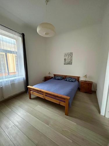 a bedroom with a bed and a large window at Spacious one bedroom Ausekļa apartment in Liepāja