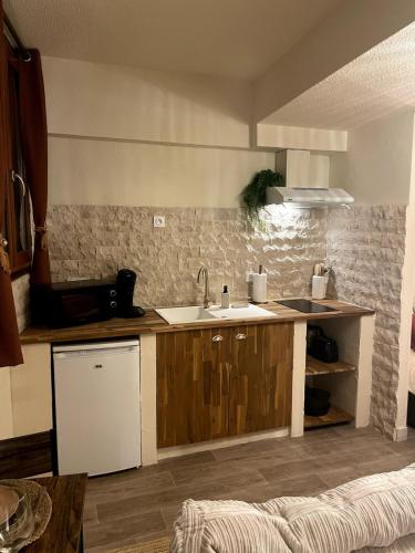 サン・ゴーダンスにあるAppartement Nid Bohème - Romantique et Cosyのシンクとカウンターのあるキッチン