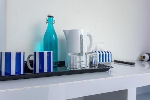 a shelf with cups and a blue bottle on it at Santorini Maafushi Maldives in Maafushi