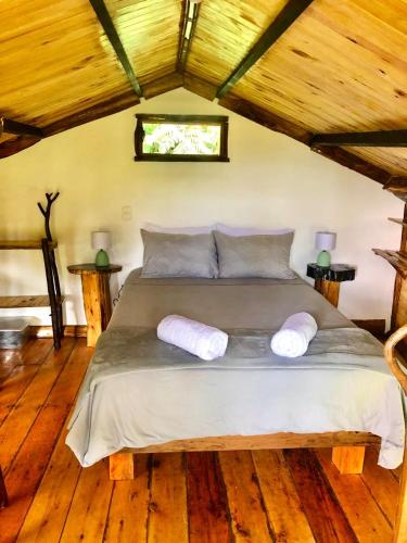 a bedroom with a large bed with two pillows on it at Las Cabanas, Finca Flora del Rio in Pijao