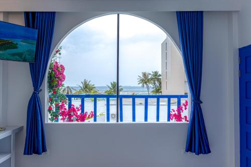 an arched window with a view of the ocean at Santorini Maafushi Maldives in Maafushi