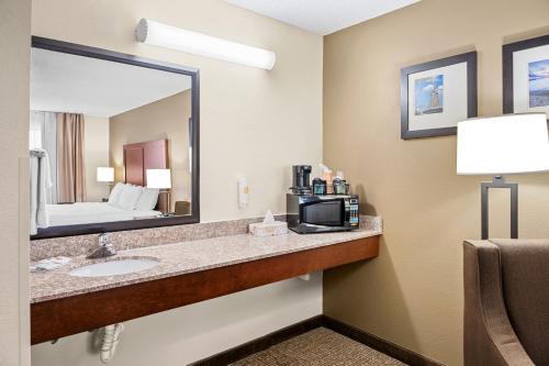 Comfort Suites Grandville - Grand Rapids SW في غراندفيل: غرفة في الفندق مع حوض ومرآة