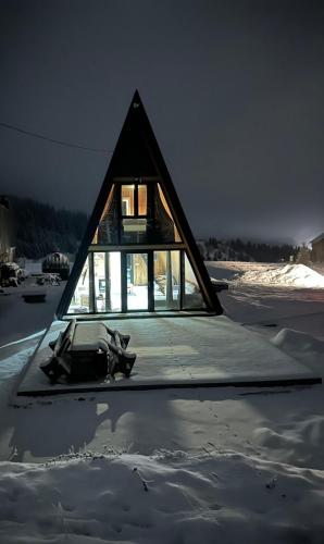 una casa sentada sobre una pila de nieve en A Frame house Slavuljica, en Vlašić