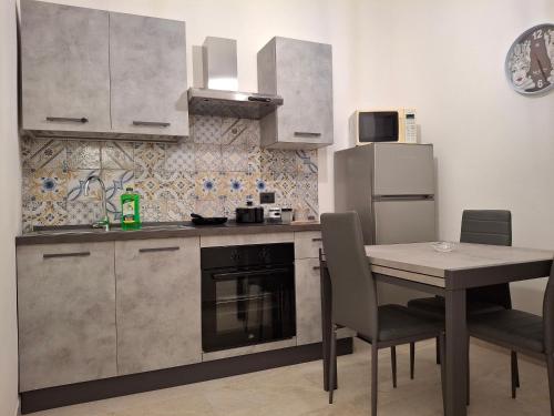 NaroCasa sul Corso的厨房配有桌子、炉灶和冰箱。