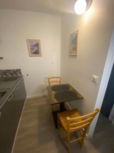 einen kleinen Tisch und Stühle in einem Zimmer mit Herd in der Unterkunft Escale sous le hêtre in Ploumilliau