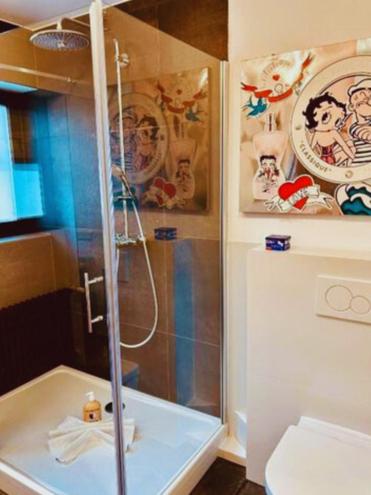 a shower with a glass door in a bathroom at Huus 17 in Rust
