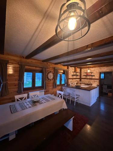 a bedroom with two beds and a kitchen and a chandelier at The Lake Breeze Bay in Plav