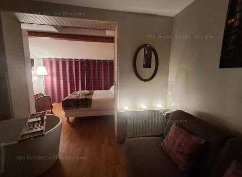 ein Wohnzimmer mit einem Bett, einem Sofa und einem Spiegel in der Unterkunft Gîte Du Côté de Chez Souesmes in Souesmes