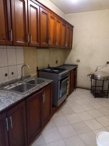 una cucina con mobili in legno, un lavello e una stufa di Guest house ad Addis Abeba