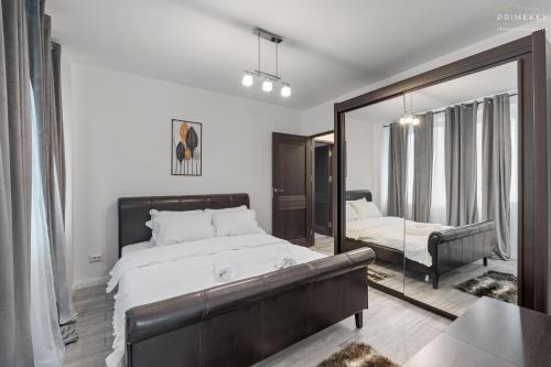 een slaapkamer met een groot bed en een spiegel bij Stylish Blue Haven 1 BR Balcony Access in Boekarest