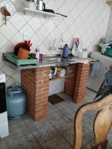 大普拉亚Casa pé na areia 40 metros da praia Caiçara的厨房配有带桌子的砖台