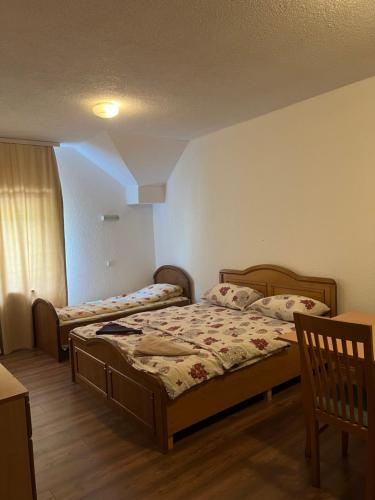 a bedroom with two beds and a window at Hotel Gryka in Peje
