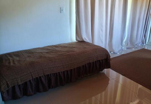 a brown blanket sitting on the floor next to a window at Suíte e casa da vania in Ilhabela