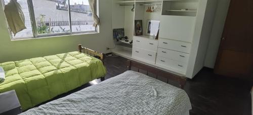 een slaapkamer met twee bedden en een ladekast bij Urubamba in San Antonio