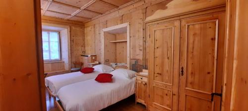 a bedroom with two beds with red pillows on them at Bella Cortina - comodo al centro e impianti, con garage in Cortina dʼAmpezzo