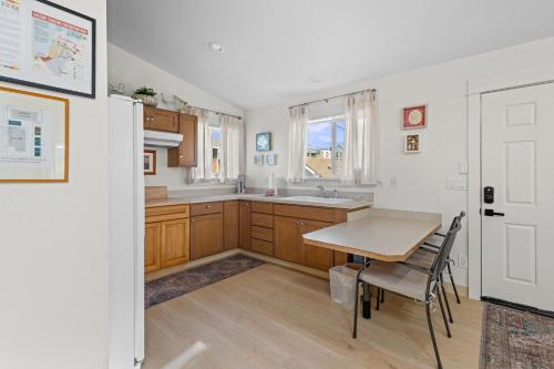 una cucina con mobili in legno, un tavolo e una finestra di Seaside Getaway A a Seaside