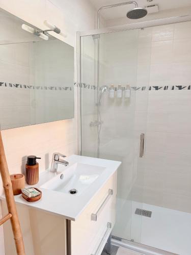 a white bathroom with a sink and a shower at La Cabane 21, Maison, Andernos-Les-Bains in Andernos-les-Bains