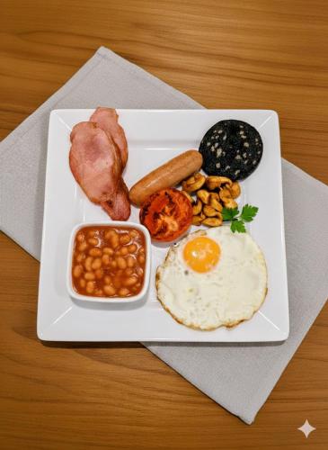 The Senarth Guesthouse - Seaside Guesthouse with Breakfast & Free Parking في خلنددنو: طبق من طعام الإفطار مع البيض والفول والفطر