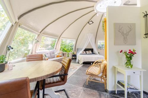 a living room with a table and chairs and a bed at Unique private guesthouse 'The Iglo' in Paterswolde