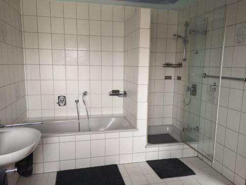 a bathroom with a tub and a sink and a shower at Ferienwohnung "Tilda" auf Hof Elseblick in Bünde