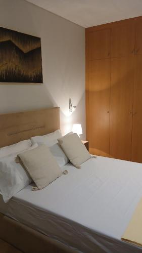 sypialnia z dużym łóżkiem z białymi prześcieradłami i poduszkami w obiekcie Clara's Place - Faia Suite w mieście Praia