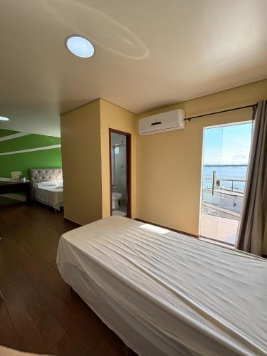 Un dormitorio con una cama y una ventana con vista al mar. en Sumaúma Hotel, en Tefé