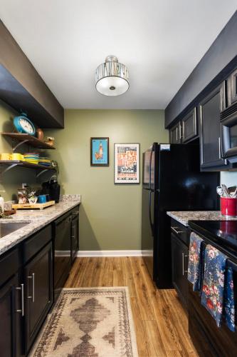 a kitchen with black cabinets and a black refrigerator at Downtown Nashville Riverfront Unit 820 in Nashville