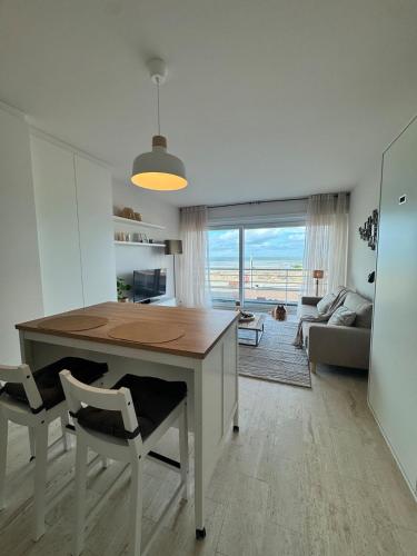 a kitchen with a table and chairs and a living room at Studio in Wenduine with frontal sea view in Mellet