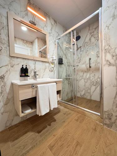 a bathroom with a shower and a sink and a mirror at Remida Managed By Dedeman in İntepe