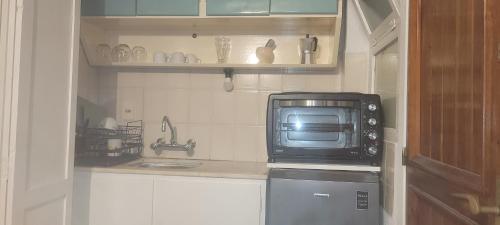 uma pequena cozinha com um micro-ondas e uma pia em 4 Mares em Punta del Este