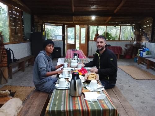two men sitting at a table with tea at Farmstay in Ibarra