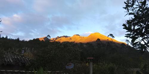 a mountain in the distance with the sun shining on it at Farmstay in Ibarra