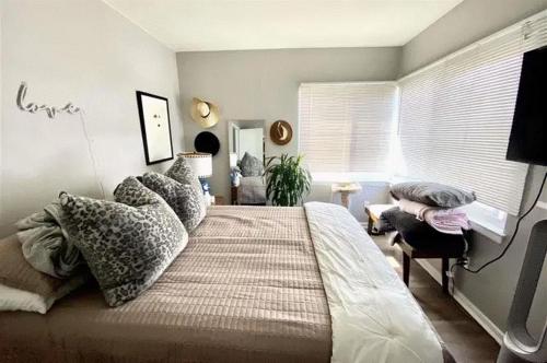 ein Schlafzimmer mit einem großen Bett mit Kissen darauf in der Unterkunft Modern City View at Lake Merritt - Balcony in Oakland