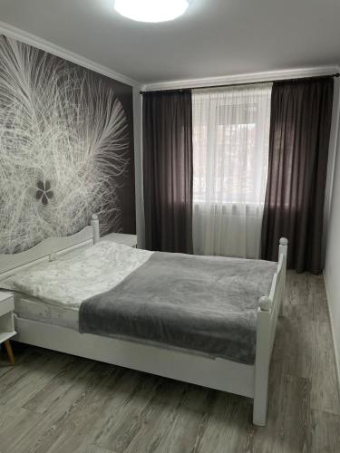 una camera da letto con un letto bianco e una finestra di Spacious apartment with a beautiful view a Căuşeni