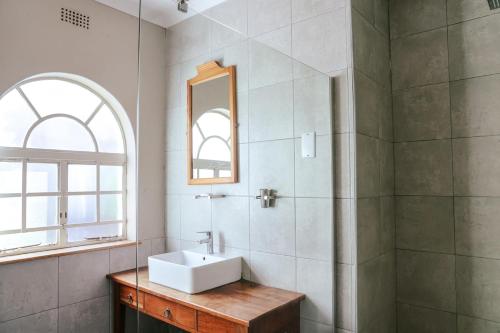 a bathroom with a sink and a shower at Borrowdale Hearthside Retreat in Harare