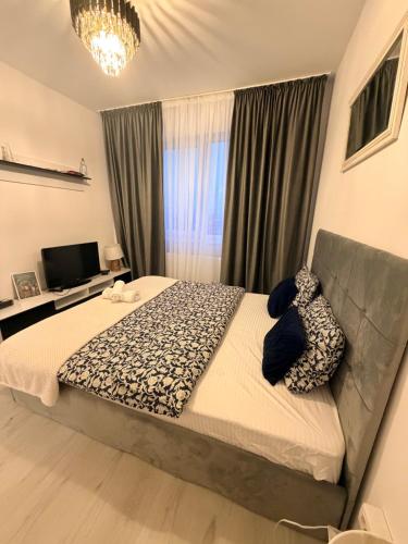 ein Schlafzimmer mit einem großen Bett und einem Fernseher in der Unterkunft DreamStay Militari Residence in Roşu