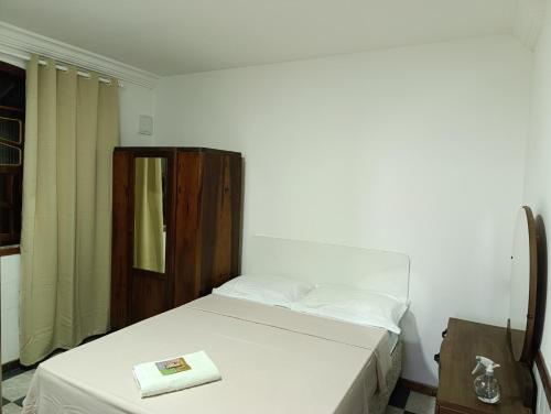 una piccola camera con letto e armadio in legno di Soledade Pousada e Apart Hotel a Morro do Chapéu