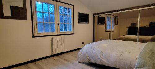 a bedroom with a bed and a large window at Chambres cosy au hameau de St Pierre in Saint-Georges-de-Commiers