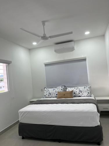 a bedroom with a large bed with a ceiling fan at Villa Karol in Rivas