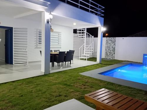 a backyard with a dining area and a swimming pool at Villa Karol in Rivas