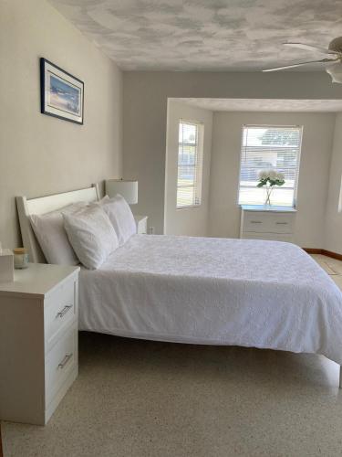 a bedroom with a white bed and a window at Historic Cocoa Village Riverwalk in Rockledge