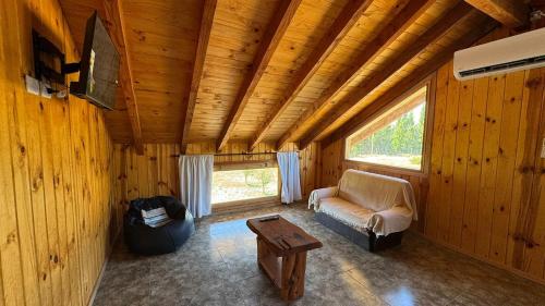 a living room with a couch and a table at Departamento a las afueras para 4 in San Martín de los Andes