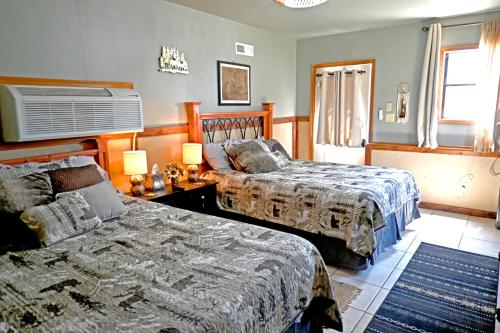 a bedroom with two beds and a table with lamps at Hotel Oasis with Outdoor Kitchen in Fall River