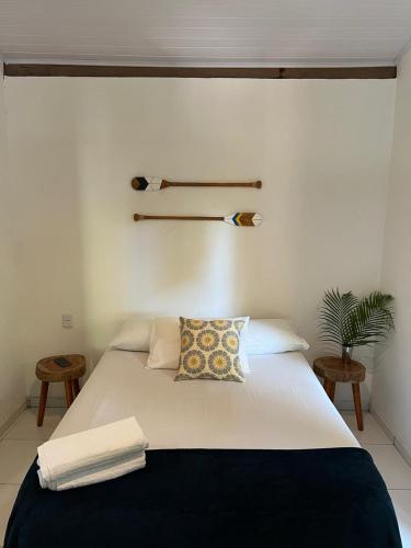 a bedroom with a white bed with a pillow on it at Casa da Vila in Caraíva