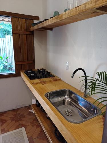a kitchen with a sink and a stove at Casa da Vila in Caraíva