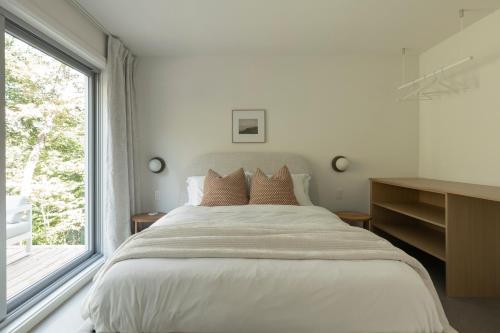 a bedroom with a large bed and a window at Maison Solus - Mont Tremblant in Lac-Superieur