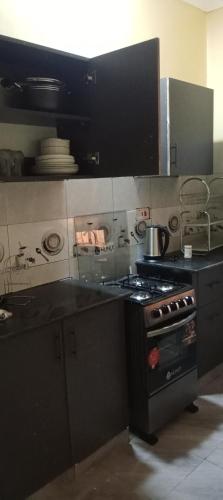 a kitchen with a stove and a counter top at Rosslyn suites in Juja