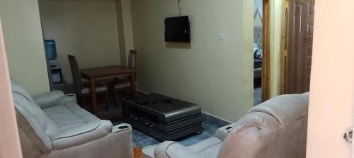 ein Wohnzimmer mit zwei Sofas und einem Fernseher in der Unterkunft Rosslyn suites in Juja