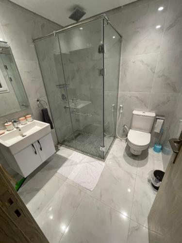 een badkamer met een douche, een toilet en een wastafel bij Marina Suite in Hurghada
