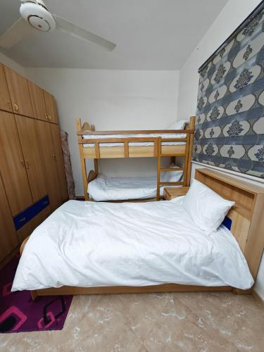 Un dormitorio con dos literas con sábanas blancas. en Luxury Apartments, en Áqaba